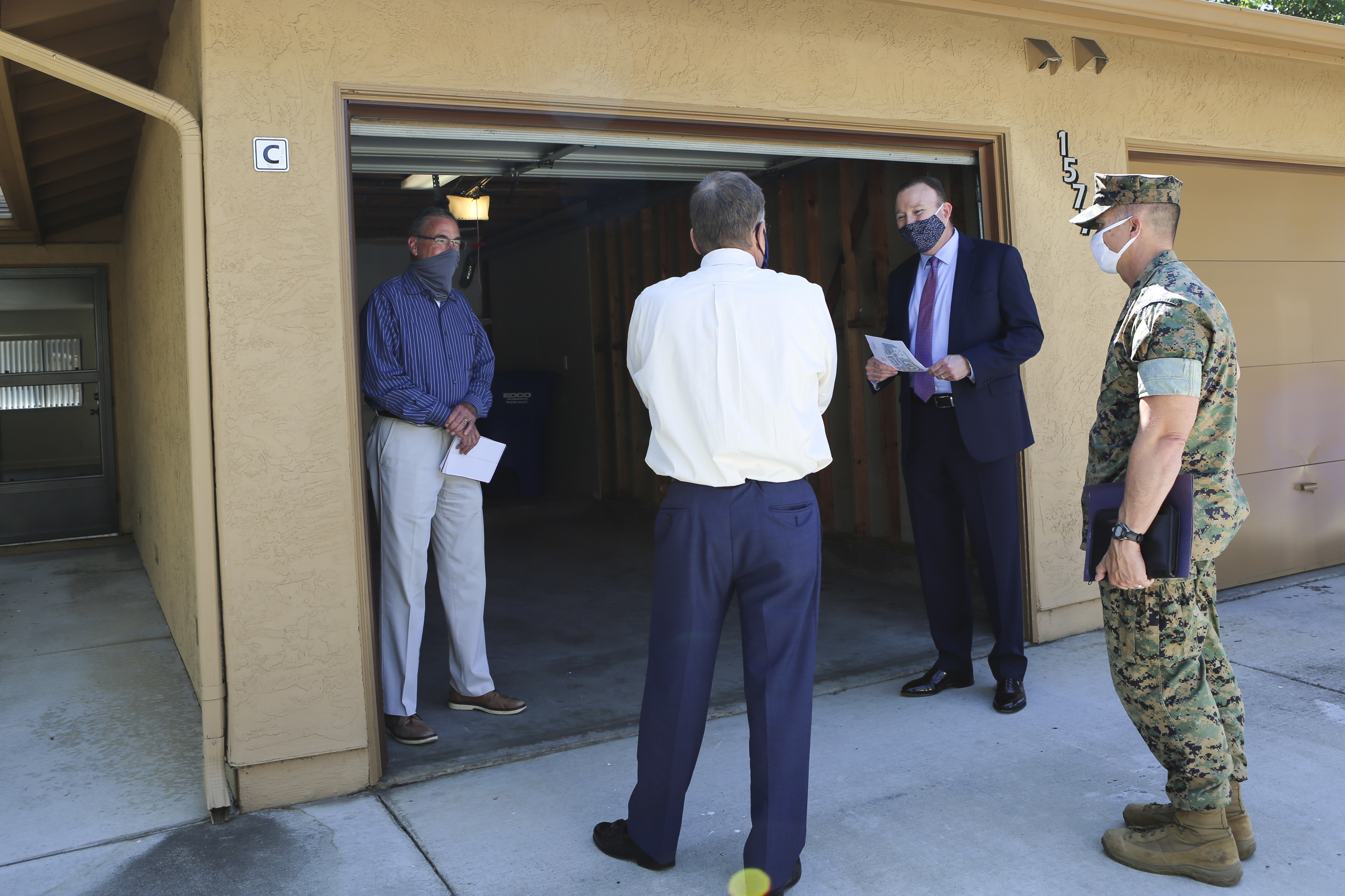 Men standing outside of a garage.